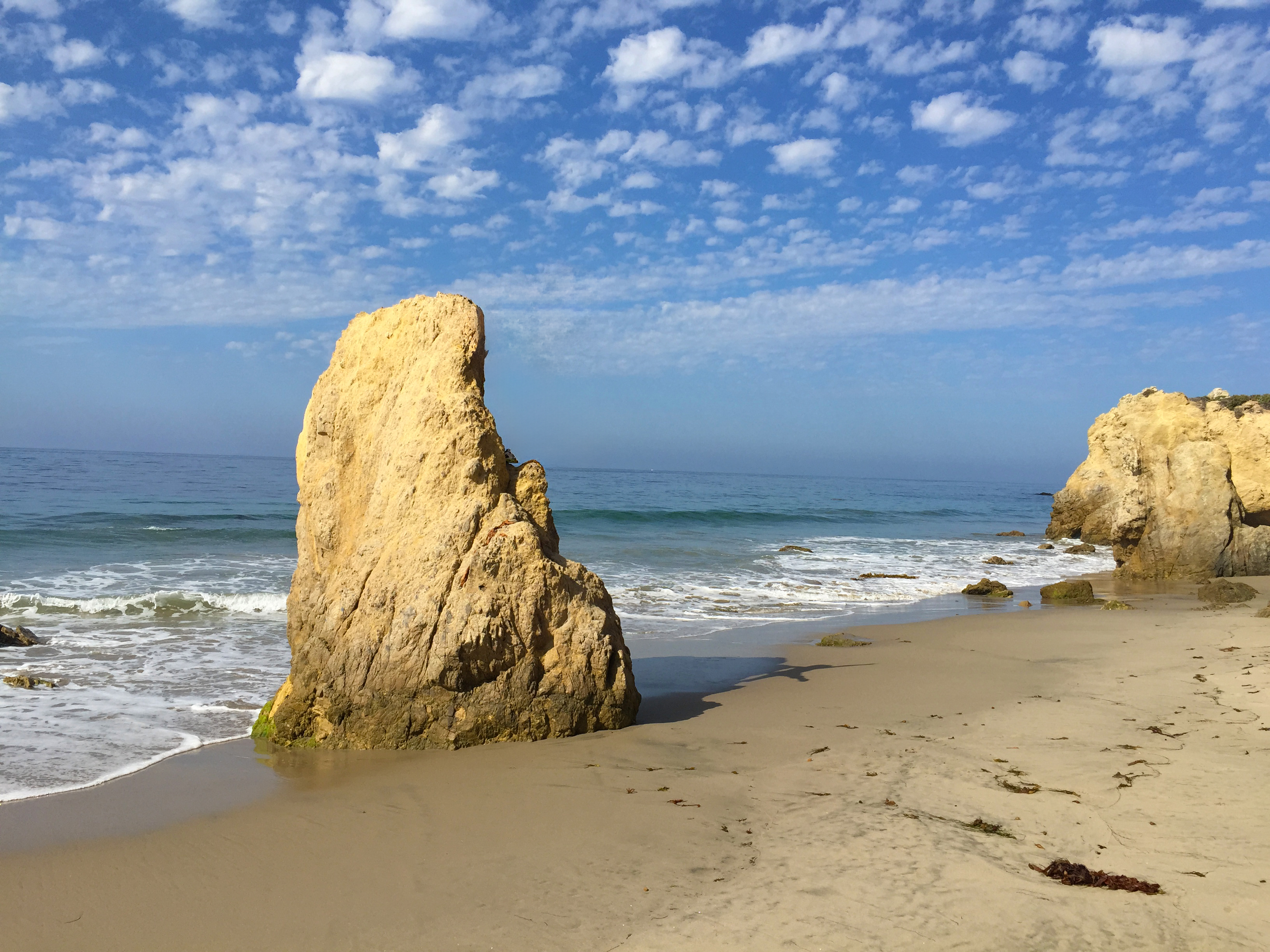 Sunlit sandstone pillar rising from a quiet shoreline