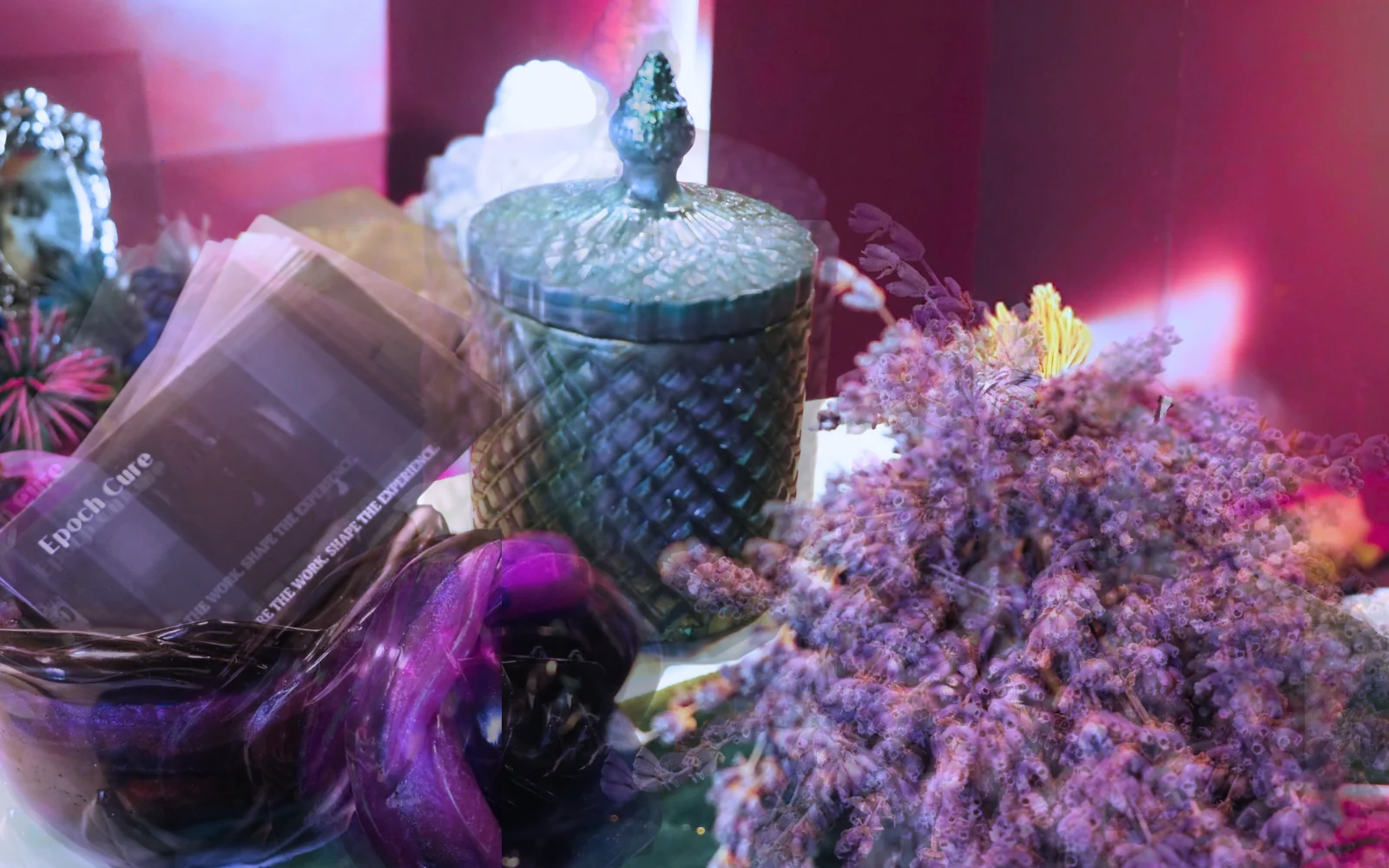 Dark still-life study with purple flowers, a green lidded object, and a translucent vessel
